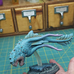 a blue dragon figurine being held by a hand