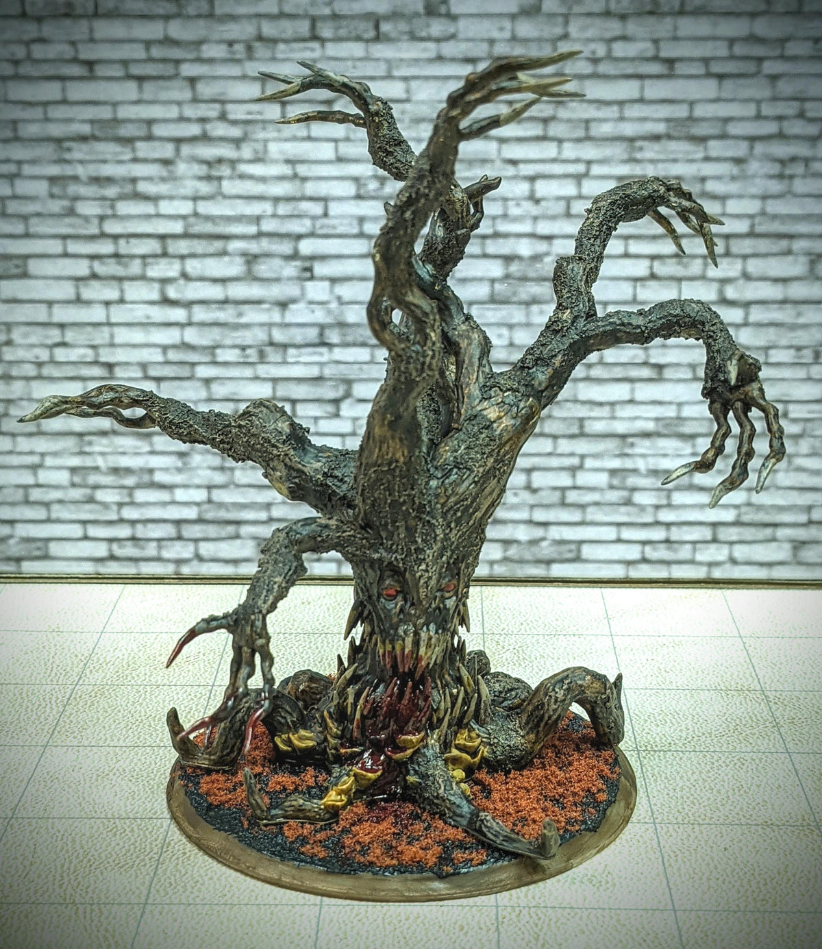 a sculpture of a tree with a brick wall in the background