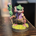 a small figurine of a cat holding a stick